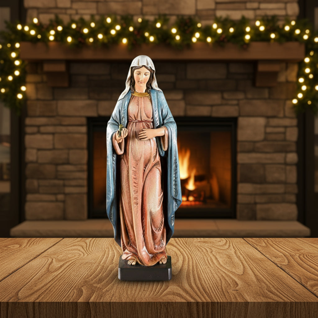 Statue of pregnant Mary in a blue robe and pink dress on a white background