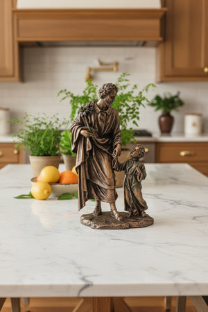 Bronze statue of a man and a child holding hands on a white background